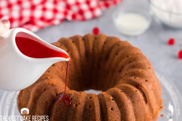 pouring cherry juice over a cake