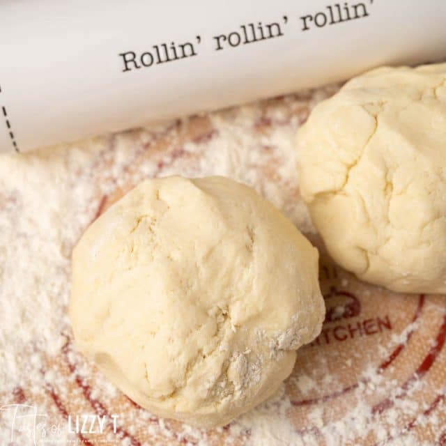 two balls of sourdough pie dough on floured surface