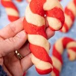 hand holding a candy cane cookie