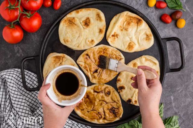 brushing balsamic reduction on naan bread