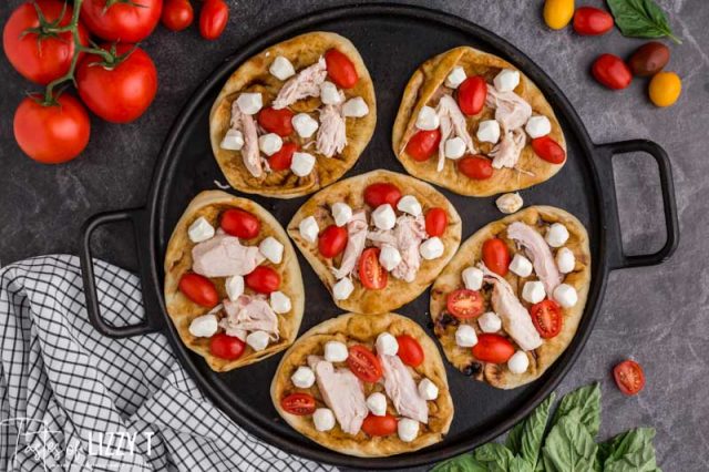 overhead view of unbaked naan pizzas