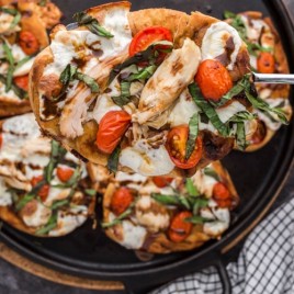 chicken caprese pizza on naan bread on a spatula