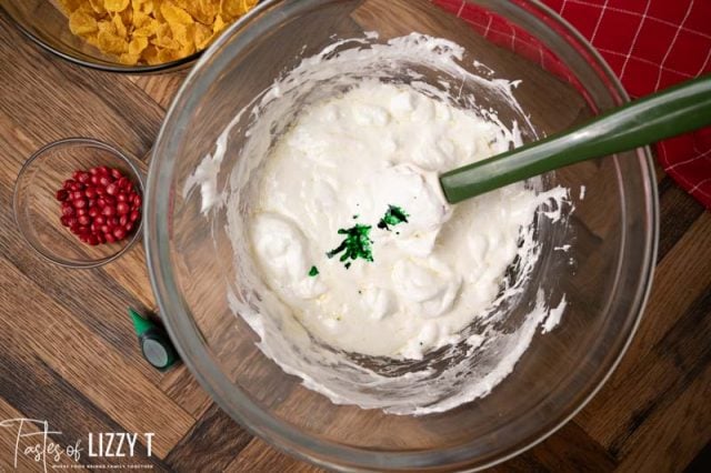 melted marshmallows in a bowl with green food color