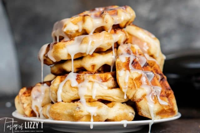 pile of cinnamon roll waffles with glaze on a plate
