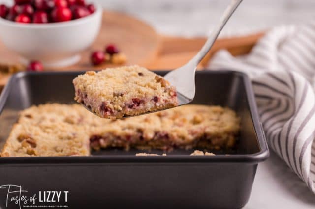 cranberry cream cheese bars in a pan on a spatula