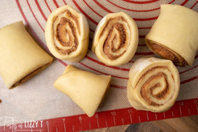 unbaked cinnamon rolls on a pastry mat