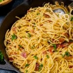 pasta carbonara in a skillet with a serving spoon