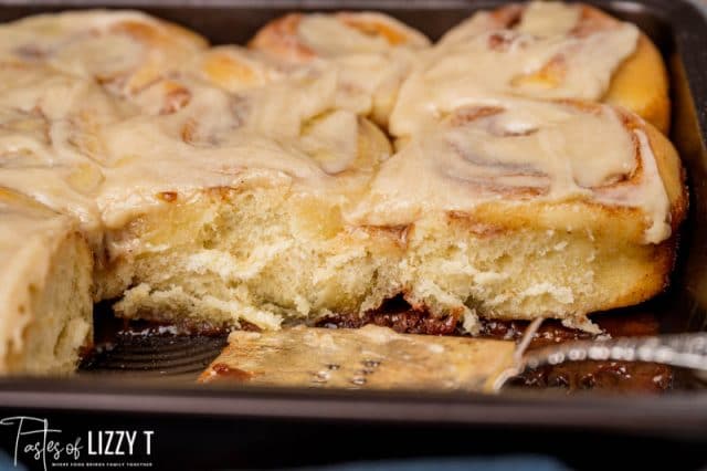 cinnamon rolls in a pan with two missing