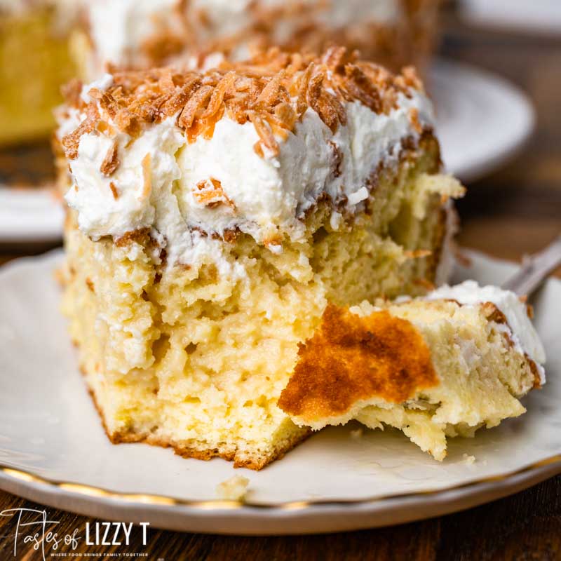 a piece of coconut cake on a plate with a bite out