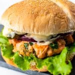 salmon burger with lettuce and tartar sauce on a bun