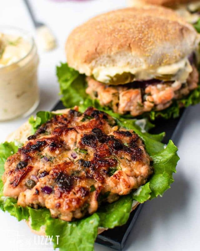 golden brown salmon burgers on lettuce