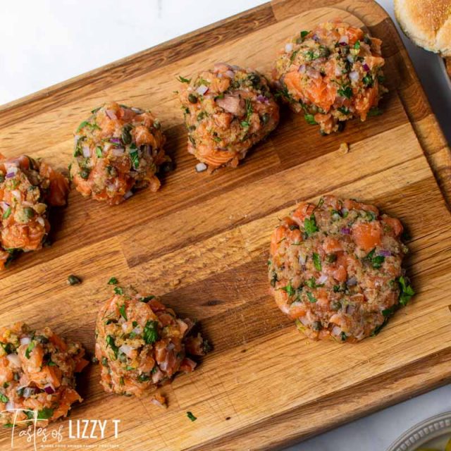 uncooked salmon burgers on a cutting board