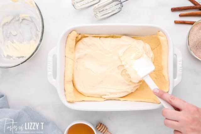 spreading cream cheese on crescent rolls