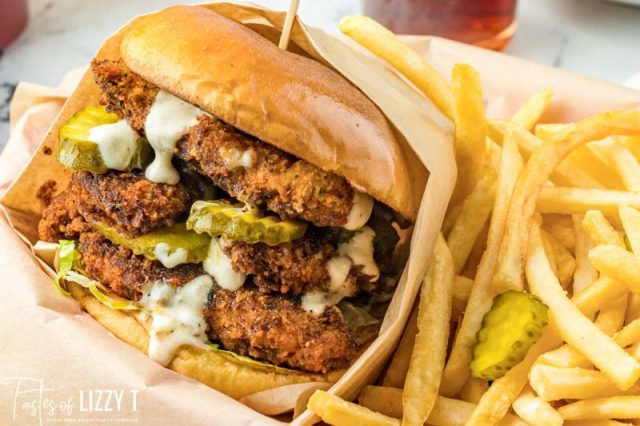 spicy chicken sandwich in a basket with fries