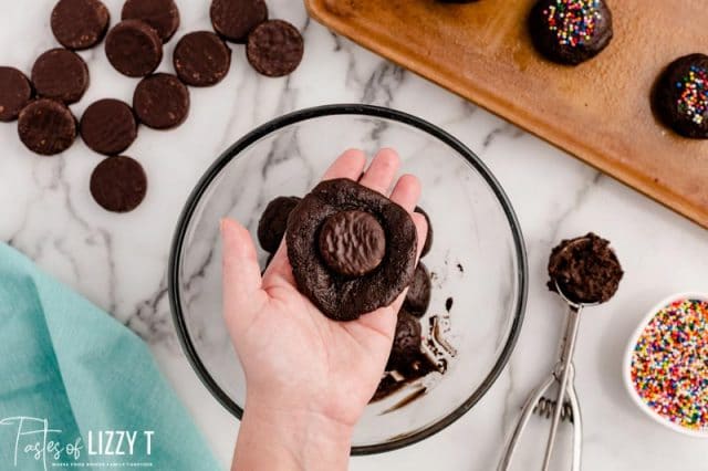 shaping cookie dough around a peppermint patty