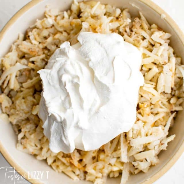 sour cream over hashbrown mixture in a bowl