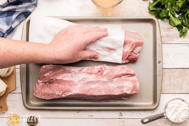 drying pork loin with a paper towel