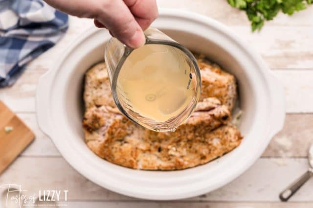 pouring broth over pork loin