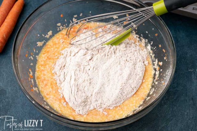 flour over pancake batter in a bowl