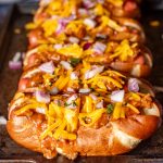loaded chili dogs on a baking sheet