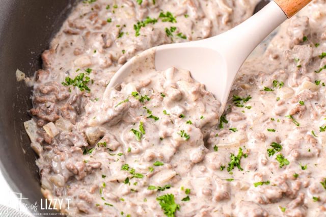 ground beef gravy in a skillet with a spoon