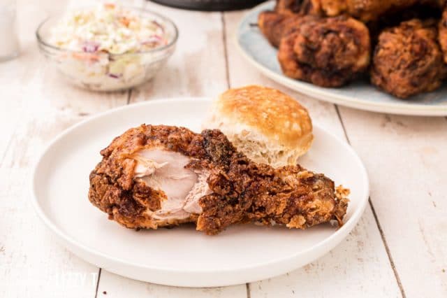 a chicken drumstick with a bite out on a plate