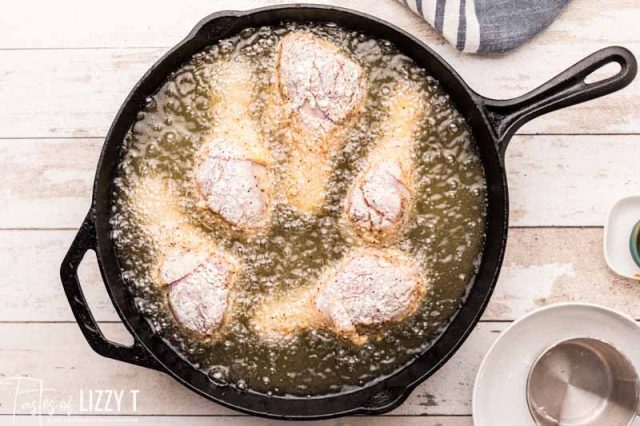 chicken frying in a cast iron skillet
