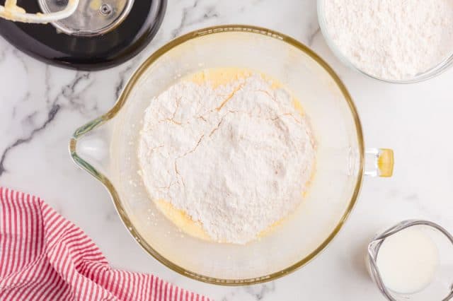 flour over egg mixture in a mixing bowl