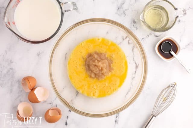 mixing applesauce into eggs in a bowl