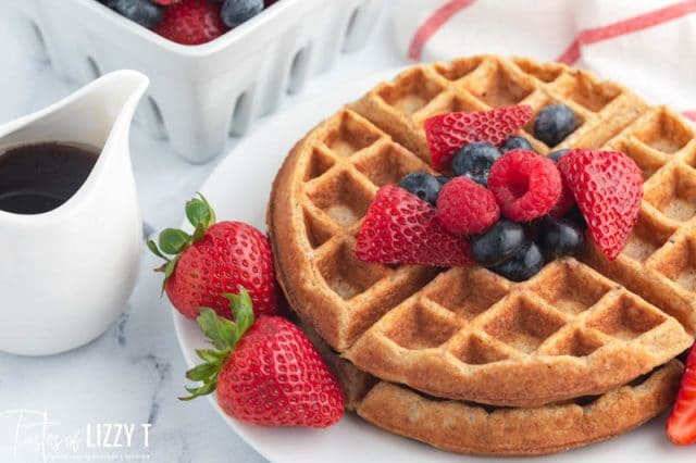 two whole grain waffles on a plate with fresh berries