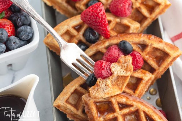 a piece of waffle and berries on a fork