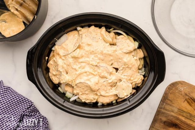 uncooked cheesy potatoes in a crockpot