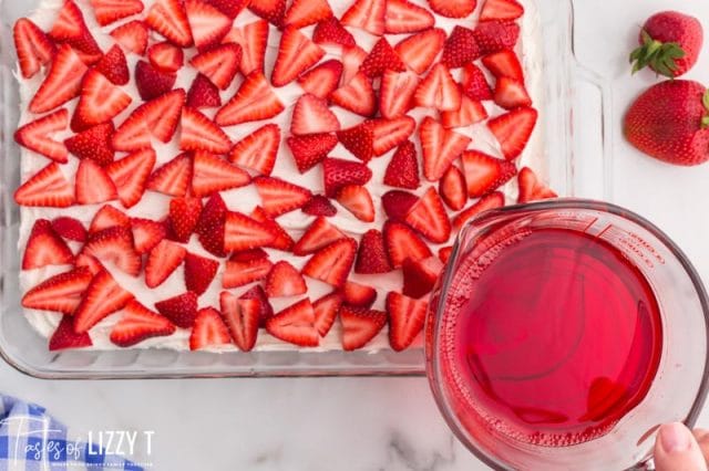 pouring jello over strawberries