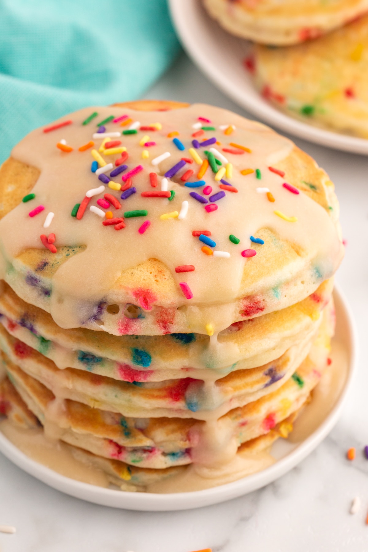 stack of funfetti pancakes with glaze and sprinkles