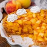 a peach pie on a table with one slice missing