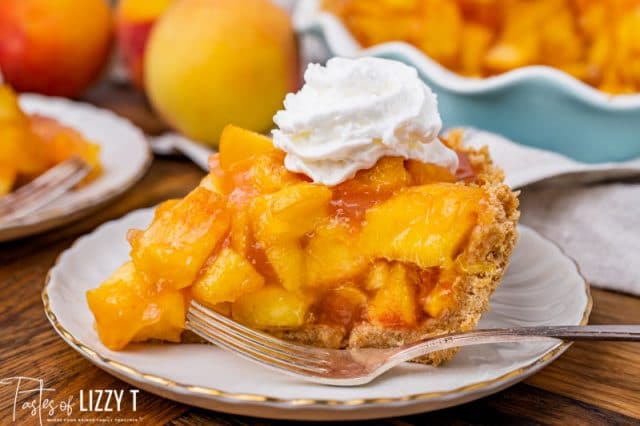 a piece of pie with fresh peaches and whipped cream