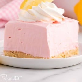 a closeup of a piece of pink lemonade bar on a plate