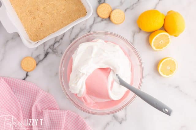 mixing cool whip into pink lemonade mix