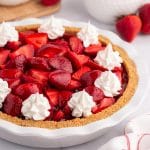 strawberry pie with whipped cream on a table