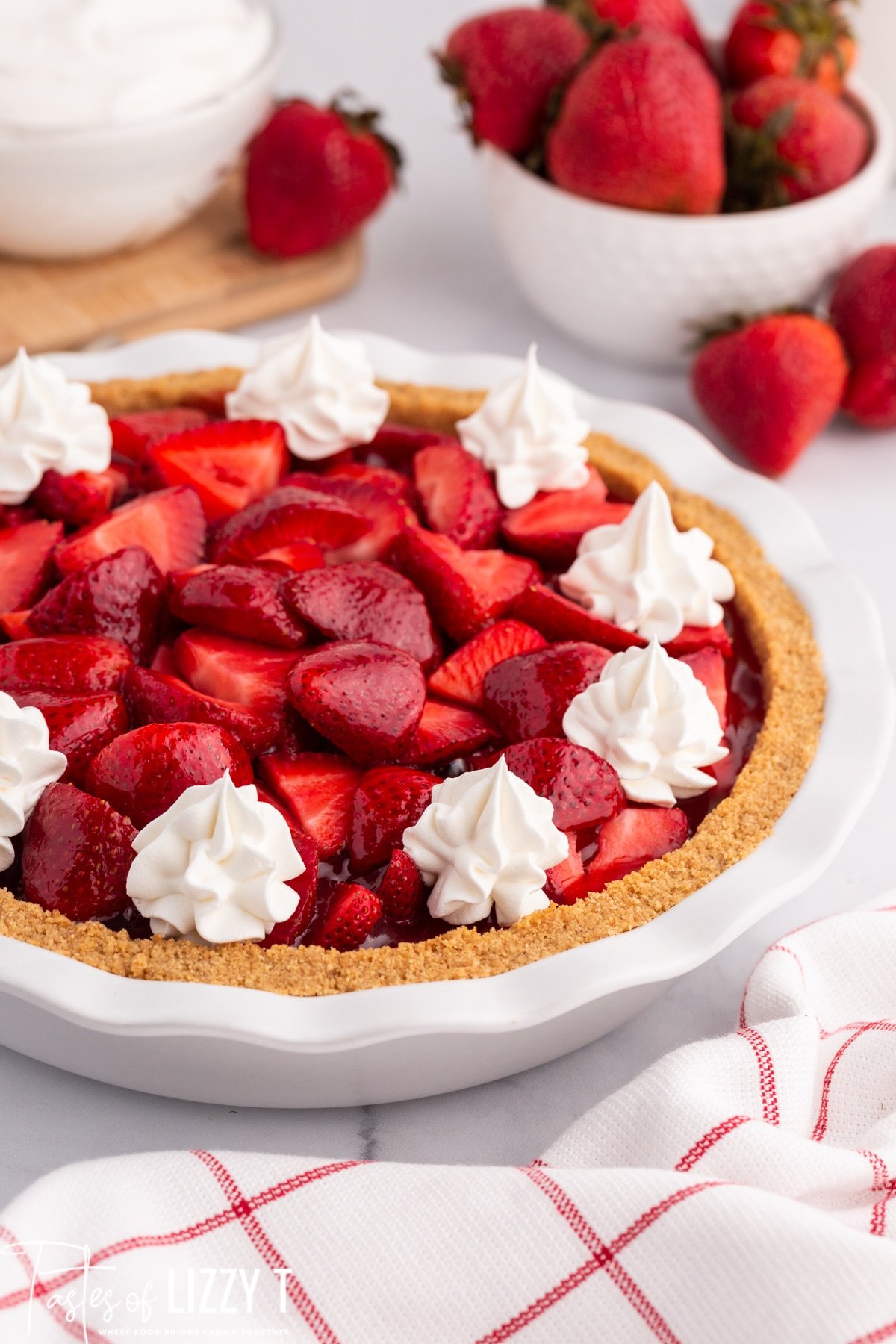 strawberry pie with whipped cream on a table