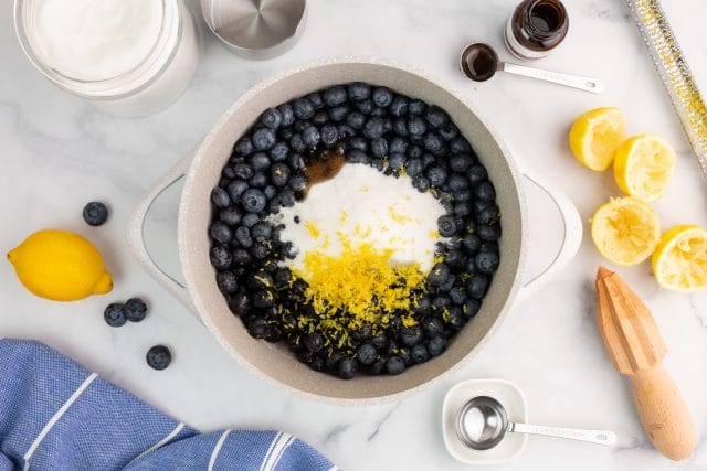 ingredients for blueberry jam in a saucepan