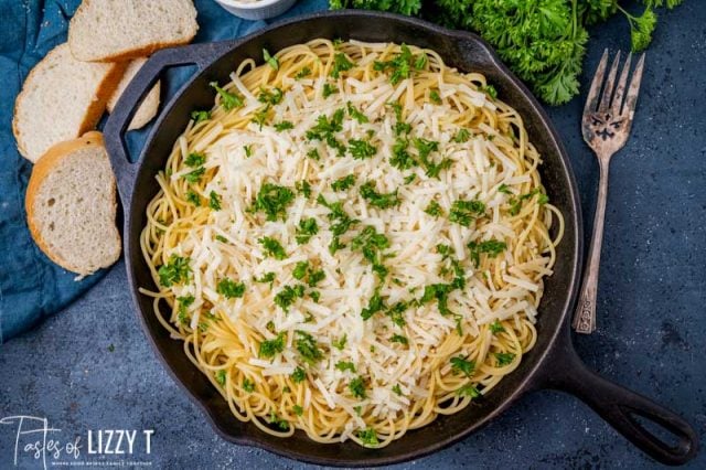 shredded cheese in spaghetti in a skillet