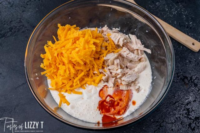 cheese, chicken and buffalo sauce in a mixing bowl