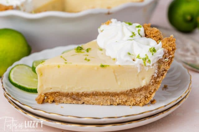 a slice of lime pie on a plate with limes