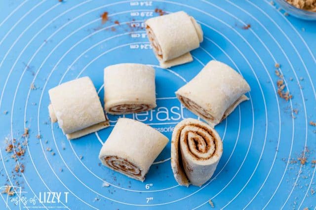 cut cinnamon rolls on a baking mat