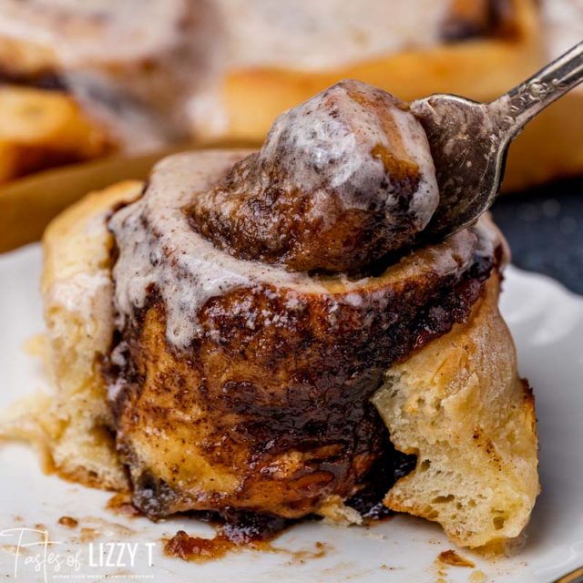 fork pulling out the center of a cinnamon roll