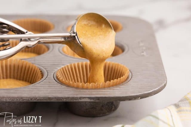 scooping batter into muffin cups