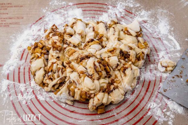pile of apple fritter dough on a pastry mat