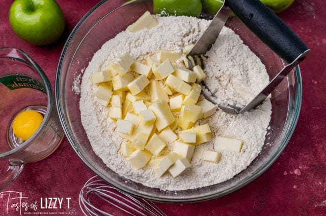 butter over flour in a bowl with a pastry cutter