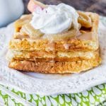 three waffles on a plate with apple slices and cinnamon syrup